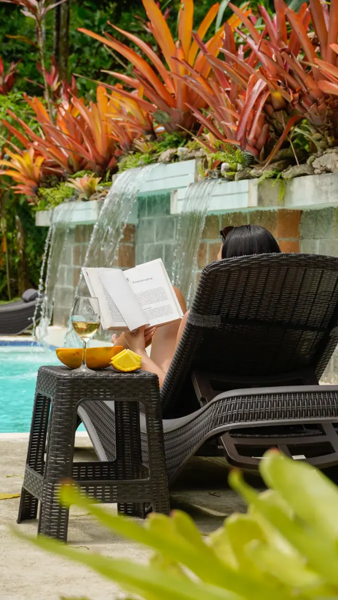 Reading on a lounger next to the pool waterfall