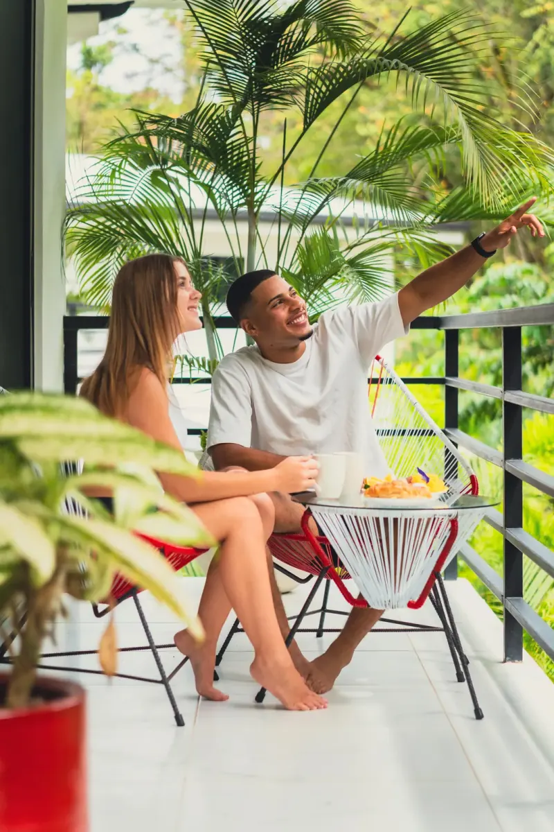 Couple laughing at a table on the balcony