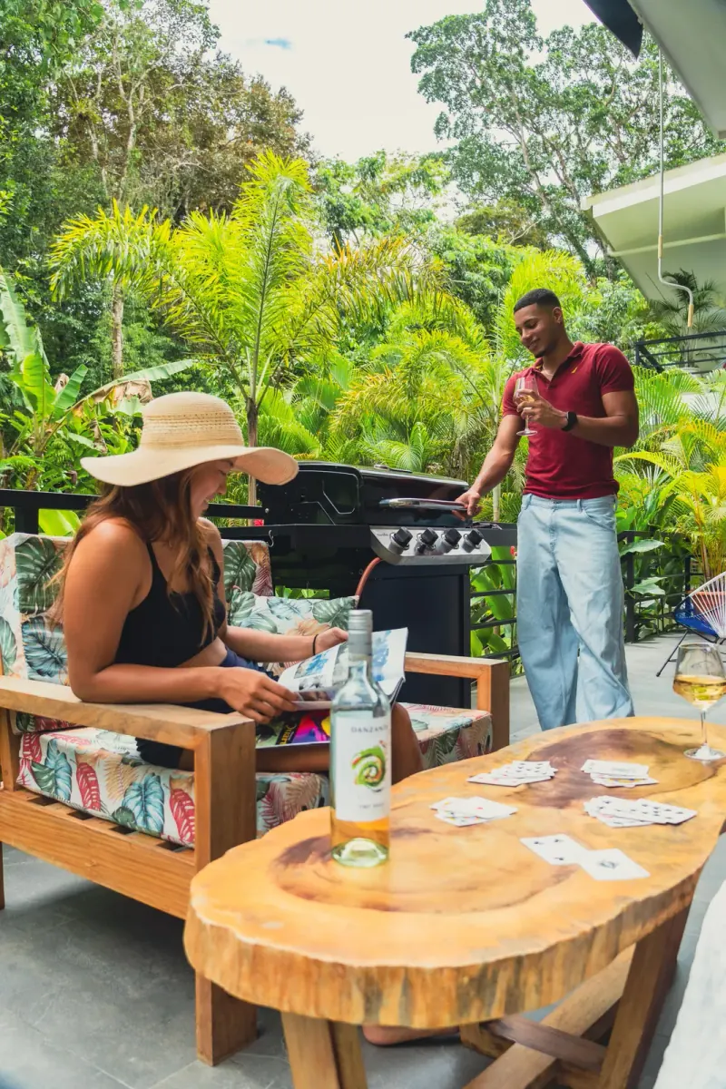 Friends relaxing while one grills on the barbecue