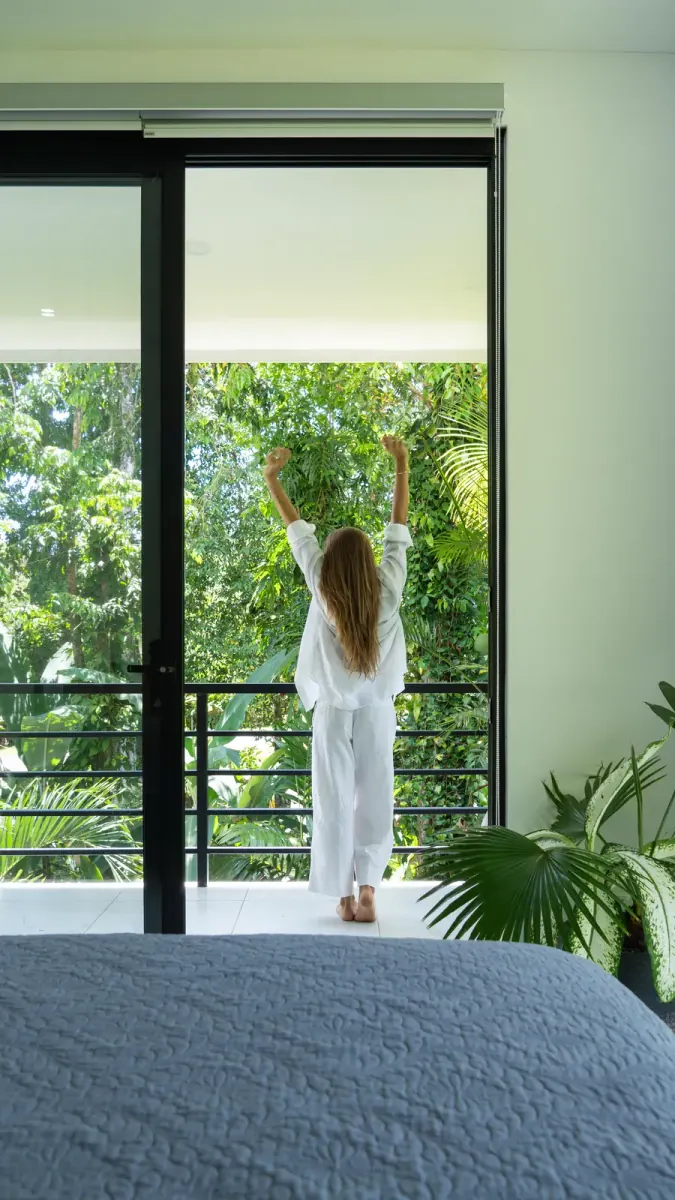 Woman stretching on a balcony overlooking the jungle
