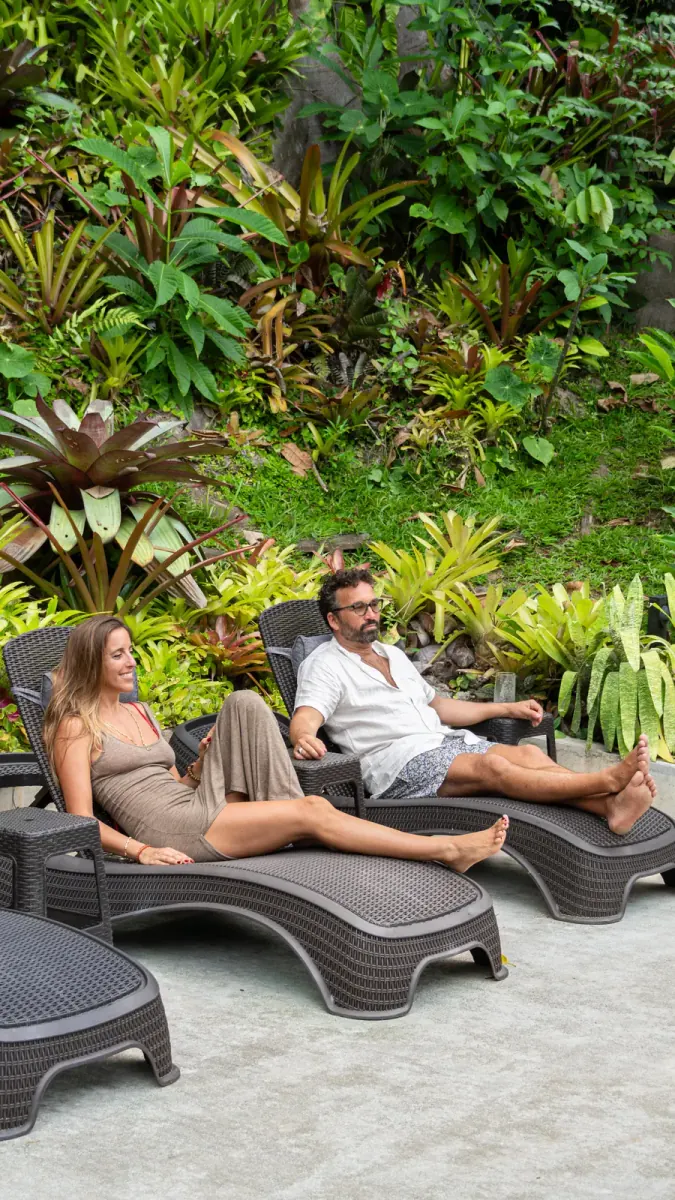 Couple relaxing on lounge chairs in the garden