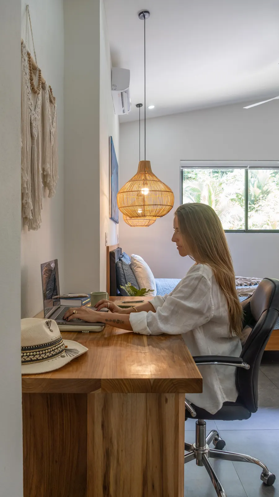Woman working on a laptop at a desk in a villa