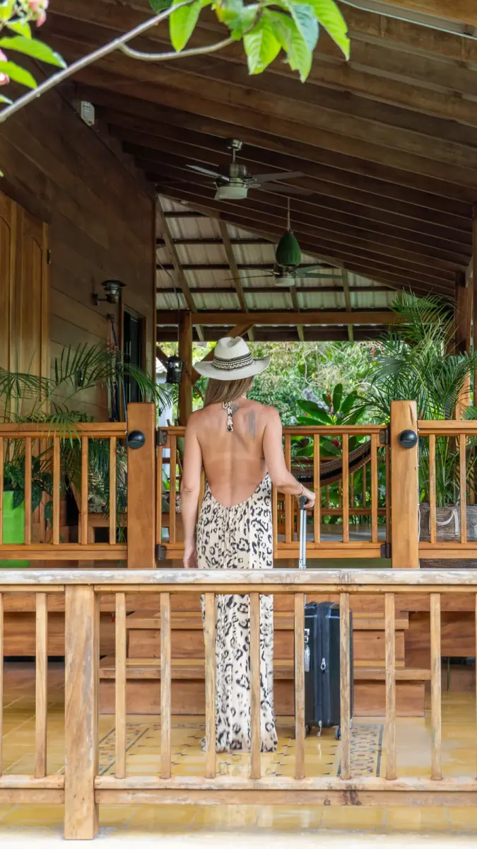 Woman in a sun hat walking across a wooden rancho